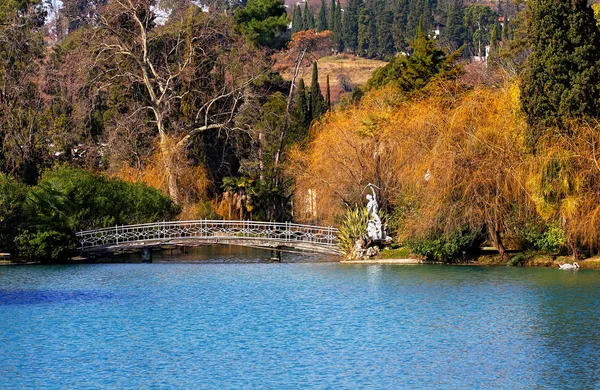 Embankment of the pond with white bridge — Stock Photo, Image
