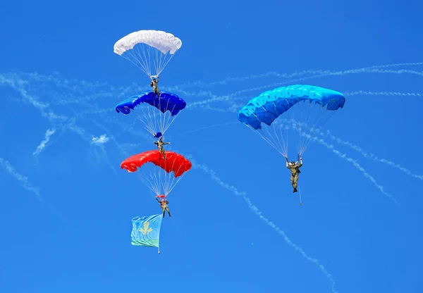 Парашютисты в голубом небе — стоковое фото