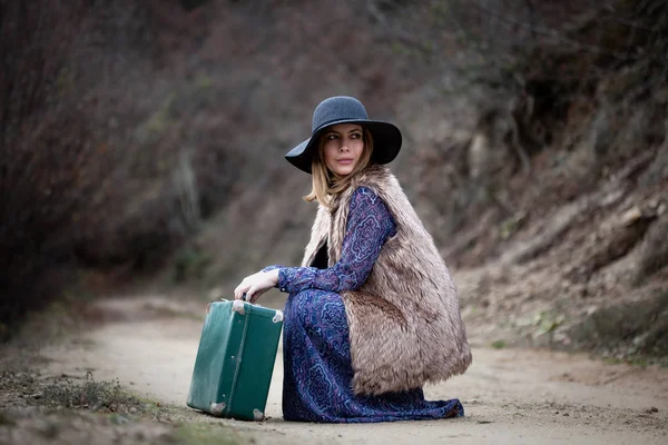 Bella ragazza con caso vintage su un Dirtroad — Foto Stock