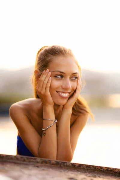 Girl on an upside down rowboat smiling — Stock Photo, Image