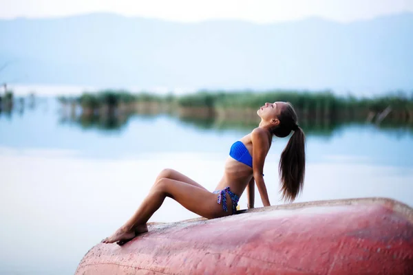 Menina de cabeça para baixo remo barco tiro no por do sol — Fotografia de Stock