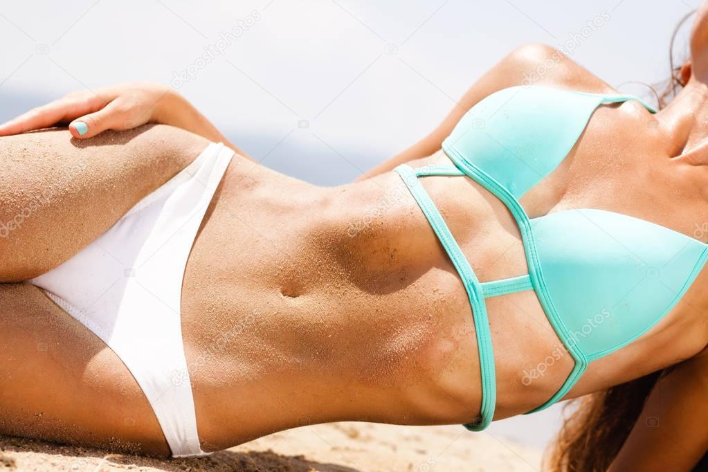 female body covered with sand