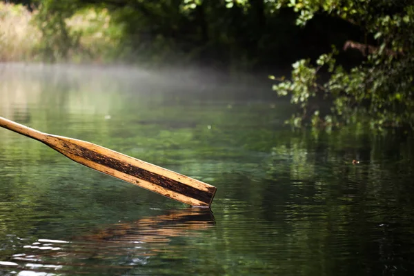 Wooden paddle over misty water — Stock Photo, Image