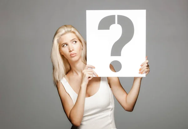 Blond girl holding a question mark sign — Stock Photo, Image
