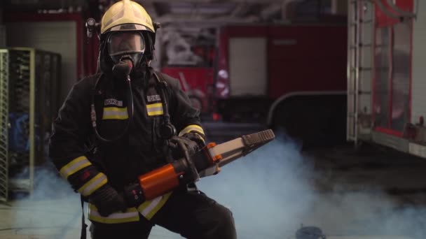 フル装備 酸素マスク 緊急救助装置 油圧クランプ 煙と背景に消防車を身に着けている消防士の肖像画 — ストック動画