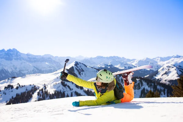 Snowboardowe dziewczyna pozowanie na śniegu z kamery akcji — Zdjęcie stockowe