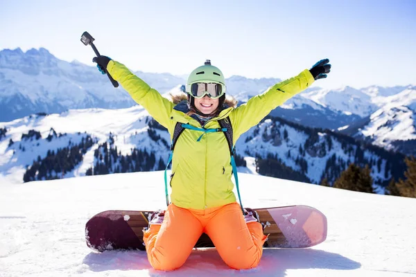 Snowboard chica posando en la nieve con acción cámara —  Fotos de Stock