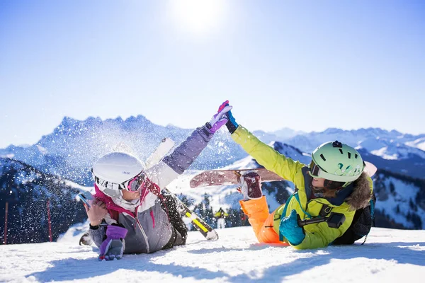 Two girls with ski and snowboard having fun on snow — 스톡 사진