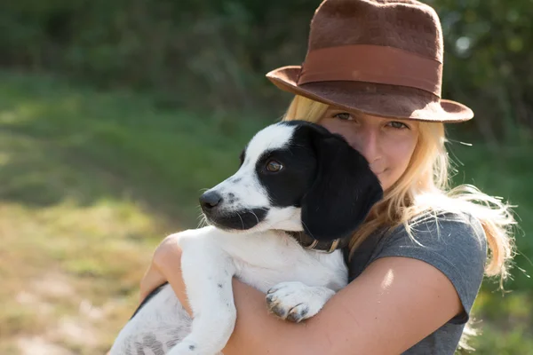 Mujer con lindo cachorro jugando — Foto de Stock