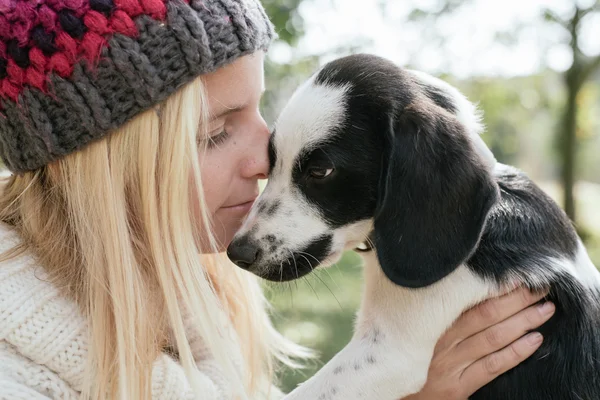 Mujer con lindo cachorro jugando — Foto de Stock