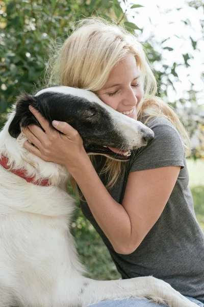 Mujer con lindo cachorro jugando — Foto de Stock