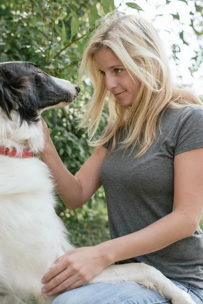 Mujer con lindo cachorro jugando — Foto de Stock