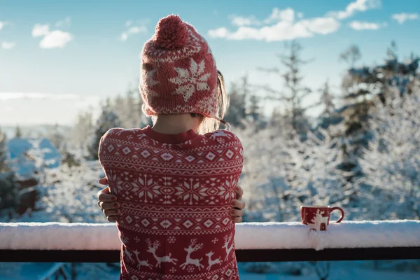 Fiatal nő figyelte a hóval borított táj, erkély — Stock Fotó