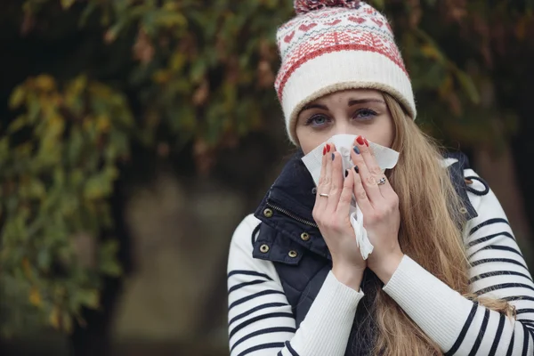 Young woman blowing her nose — Stock Photo, Image