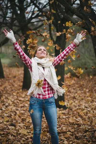 Femme heureuse jouant avec les feuilles d'automne — Photo