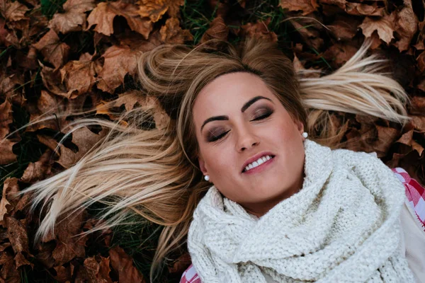 Femme couchée sur les feuilles d'automne — Photo