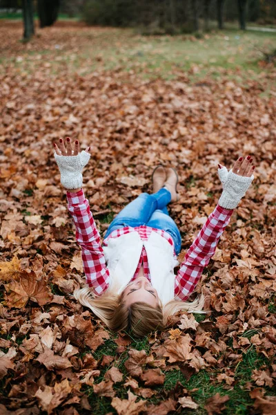 Žena leží na podzimní listí — Stock fotografie