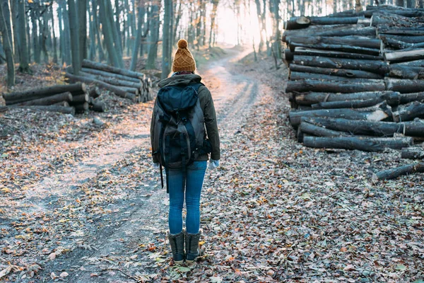 Жінка з рюкзаком в осінньому лісі — стокове фото