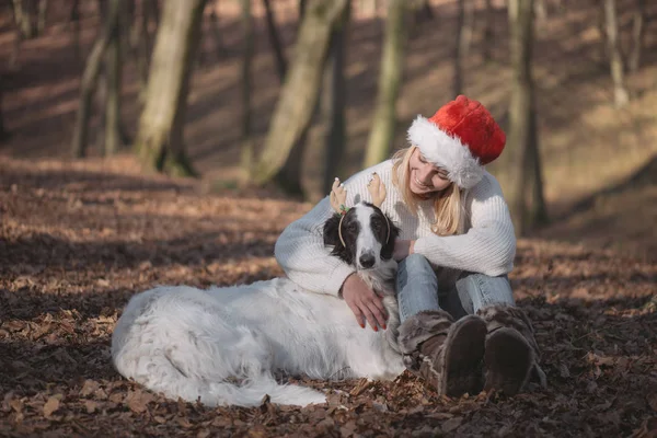 Fiatal nő santa kalap aranyos kutya — Stock Fotó