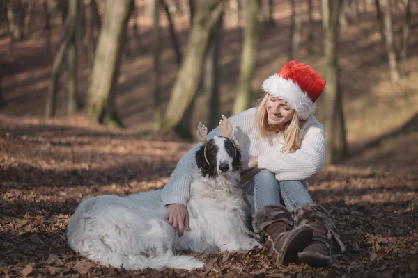 Fiatal nő santa kalap aranyos kutya — Stock Fotó