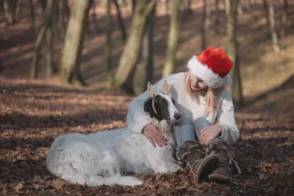 Jeune femme en santa chapeau avec chien mignon — Photo