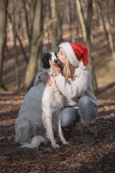 Fiatal nő santa kalap aranyos kutya — Stock Fotó