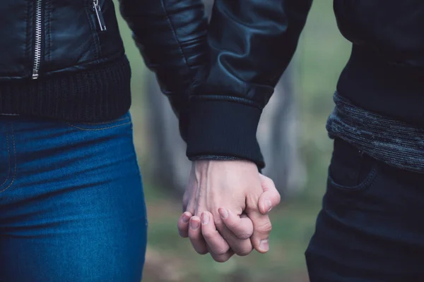 Női és férfi kezét fogalmi képe. Fiatal pár szerelmes séta a parkban, kézenfogva. — Stock Fotó