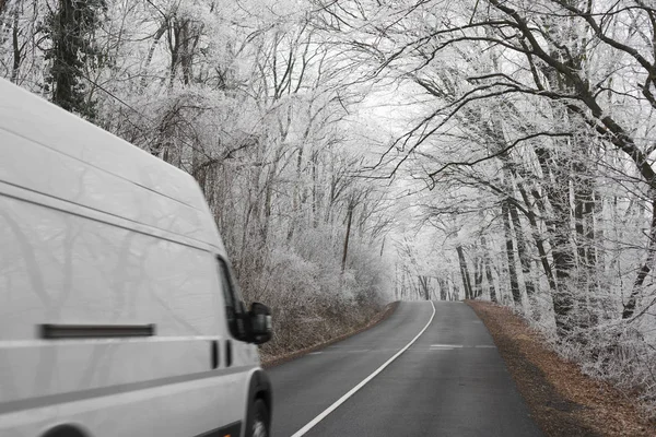 Weißer Transporter auf winterlicher Straße unterwegs — Stockfoto