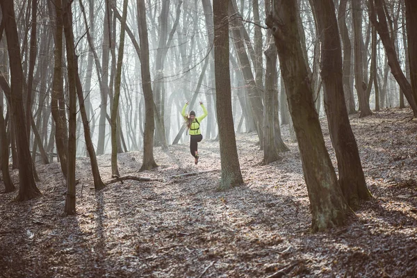 Athlète féminine courant dans le sentier forestier — Photo