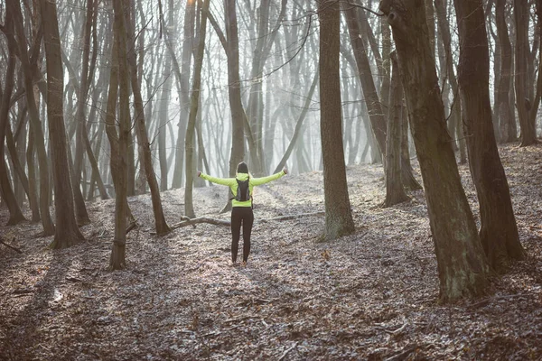 Young runner woman resting in forest after workout, arms outstretched. — Stock Photo, Image