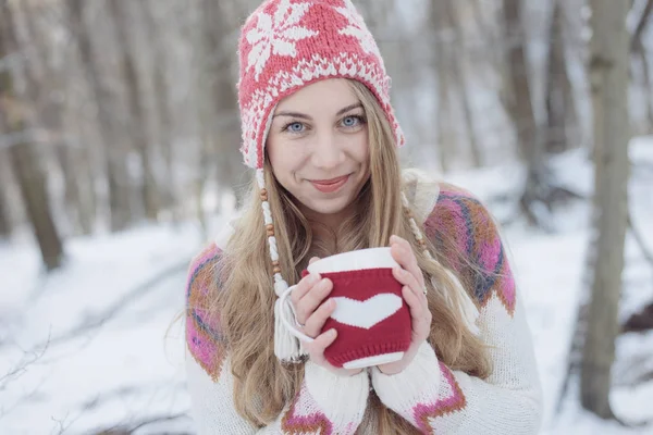 Mulher de inverno segurando uma caneca para se aquecer. Bonito jovem mulher bebendo chá ou café ao ar livre — Fotografia de Stock