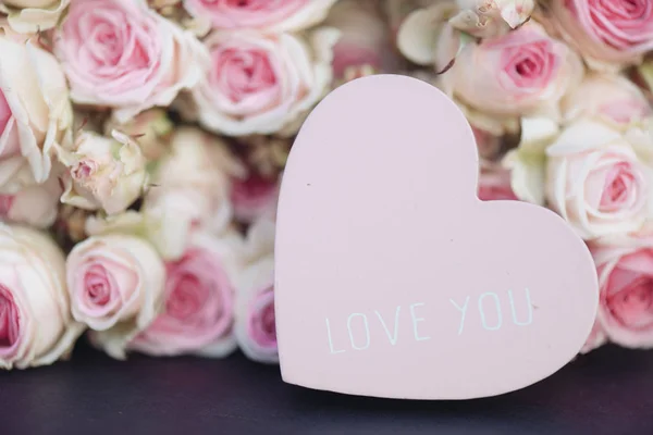 Liefde-hart en licht roze rozen achtergrond — Stockfoto