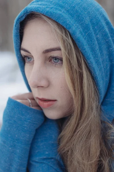Retrato de inverno de jovem bela mulher loira usando chapéu de malha. Nevando conceito de moda beleza inverno. Floresta nevada no fundo . — Fotografia de Stock