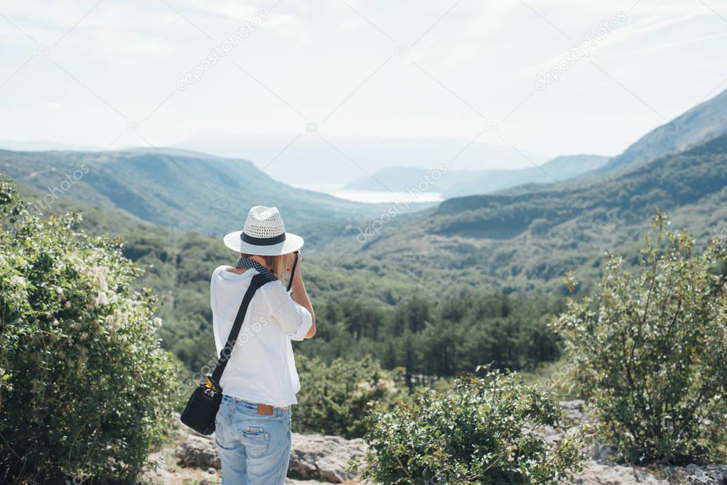 Attractive young woman talking pictures outdoors on vacation