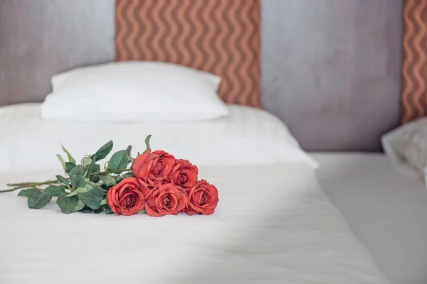 Roses on bed in fancy hotel room — Stock Photo, Image