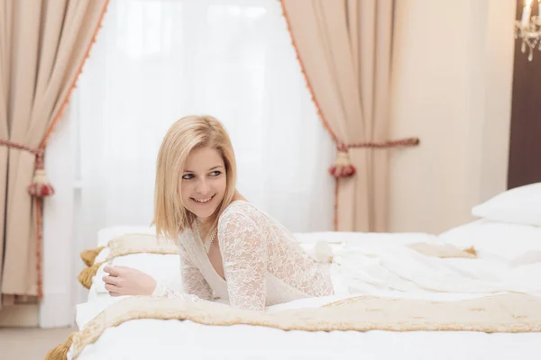 Bela noiva posando em vestido de noiva no elegante quarto de hotel — Fotografia de Stock