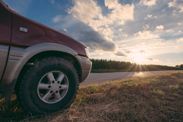 Journey concept. Off road vehicle on the rod at sunset outdoor.