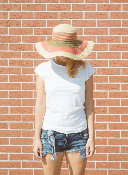 Porträt eines romantischen Mädchens mit Strohhut gegen Backsteinmauer, elegante Dame mit Hut im Sommerurlaub — Stockfoto