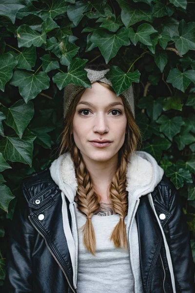 Портрет красивой брюнетки. 20-29 лет. Милая женщина стоит на фоне зеленых листьев . — стоковое фото