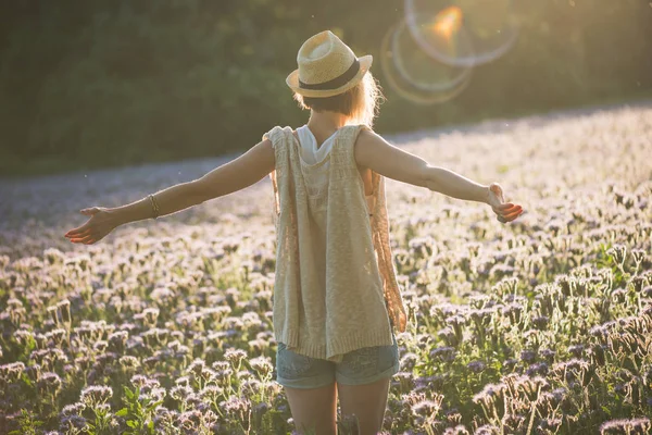 Νεαρή γυναίκα χαλαρώνοντας στο καλοκαίρι ηλιοβασίλεμα εξωτερική. Άνθρωποι ελευθερία στυλ. Νεαρά ενήλικα θηλυκά στέκεται χέρια απλωμένα. — Φωτογραφία Αρχείου