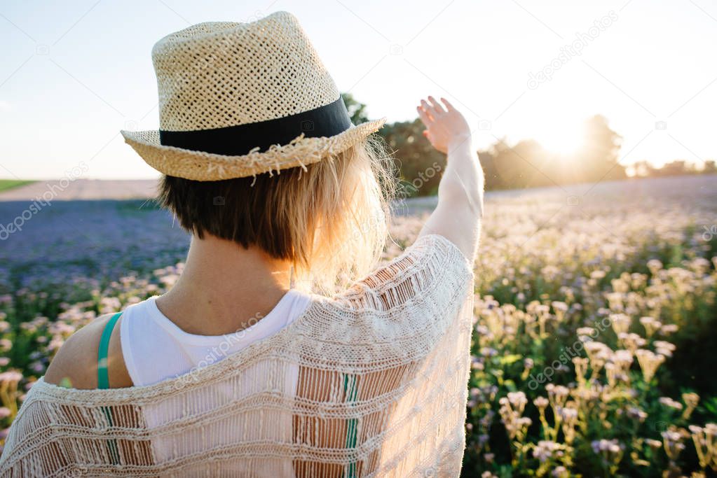 Happy woman in straw hat outdoors summer enjoying life against sun rays.
