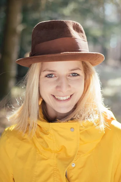 Junge erwachsene Frau im Freien lächelnd, glückliches Porträt im Freien. Hut auf dem Kopf. — Stockfoto