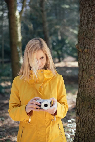 Menina loira segurando uma câmera retro, jovem é um fotógrafo com câmera vintage, ao ar livre e luz solar, Retrato, espaço de cópia . — Fotografia de Stock