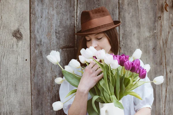 튤립 꽃, 부활절 개념의 무리와 함께 귀여운 갈색 머리 여자 — 스톡 사진