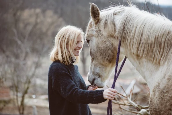 Joven hermosa mujer con un caballo — Foto de Stock
