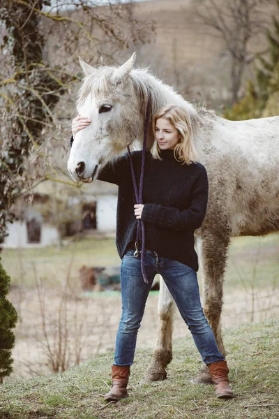 Mujer con un caballo blanco — Foto de Stock