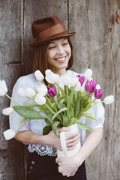Femme heureuse souriant avec un bouquet de fleurs de tulipe — Photo