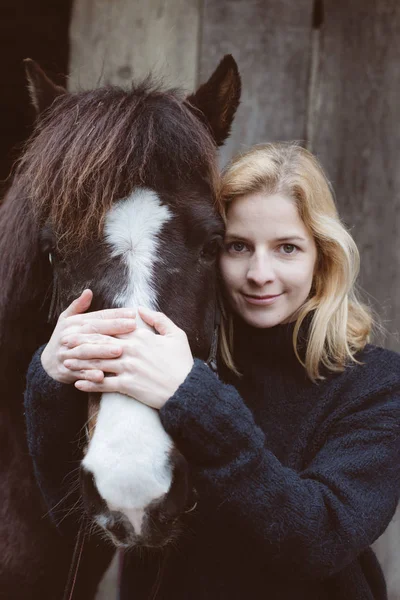 Νεαρή γυναίκα με το σκοτεινό άλογο — Φωτογραφία Αρχείου