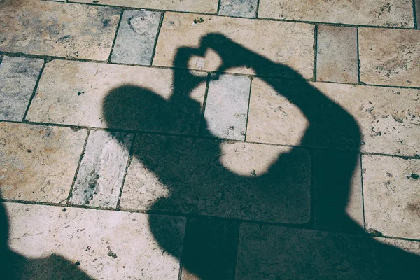 Shadow of a woman on the ground, heart texture. — Stock Photo, Image