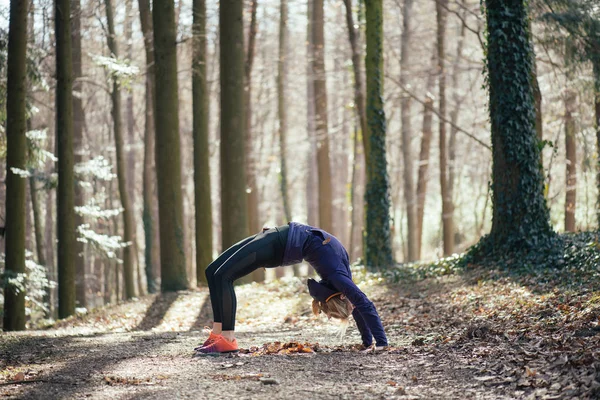 Спортивная женщина занимается спортом в лесу — стоковое фото